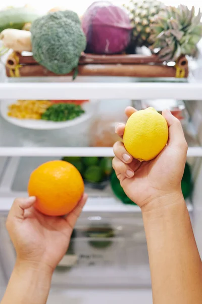 人们选择柑橘类水果作为清爽饮料 从冰箱中取出橙子和柠檬 — 图库照片
