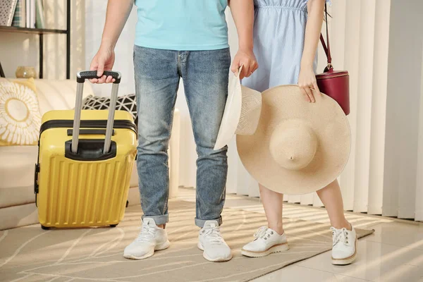 若いですカップルの低セクションでは わら帽子が部屋に立っていますスーツケース付き夏休みの準備 — ストック写真