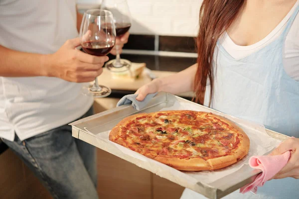 Przycięty Obraz Młodej Kobiety Przynoszącej Tacę Świeżo Zaparzoną Pizzą Stołu — Zdjęcie stockowe