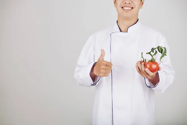 大厨拿着新鲜的西红柿 竖起大拇指 笑容满面的样子 — 图库照片