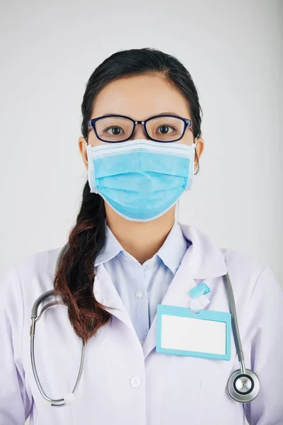 Portrét Mladé Praktičky Brýlích Lékařské Masce Odznakem Plášti — Stock fotografie