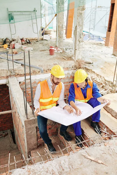 Trabajadores Construcción Sentados Pared Ladrillo Medio Hecho Discutiendo Plano Del —  Fotos de Stock