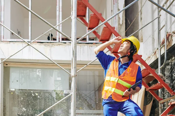 Pracownik Budowlany Pomarańczowej Kamizelce Hardhat Patrząc Sprawdzając Budowniczych Pracujących Dachu — Zdjęcie stockowe