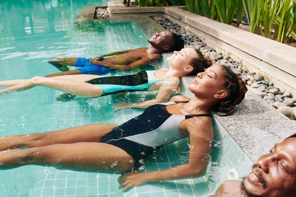 미소를 남녀들이 수영장에서 하루를 보내는 즐긴다 — 스톡 사진