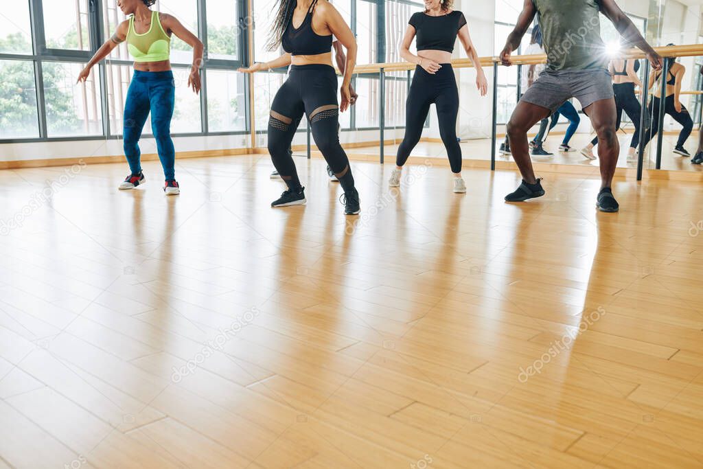 Cropped image of young men and women practicing new dance in class