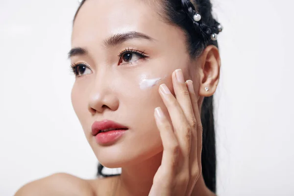 美しいです若いですベトナム人女性適用溶融保湿と若返るクリームオン彼女の顔 — ストック写真