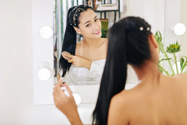 Souriant Jolie Jeune Femme Asiatique Brossant Les Cheveux Devant Vanité — Photo