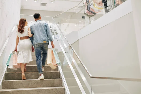 Pareja Joven Con Bolsas Compras Subiendo Las Escaleras Gran Tienda —  Fotos de Stock