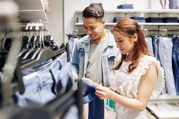 Bonito Jovem Ajudando Namorada Para Escolher Melhores Jeans Loja — Fotografia de Stock