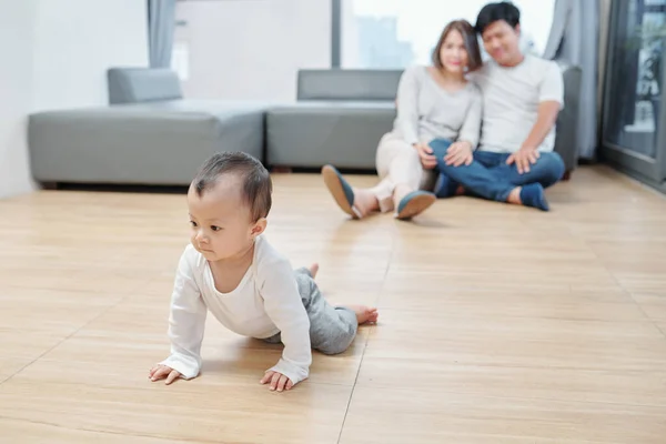Šťastní Mladí Rodiče Dívají Své Dítě Plazí Podlaze — Stock fotografie
