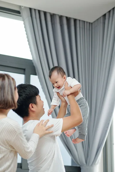 Feliz Padre Joven Levantando Bebé Recién Nacido Cuando Esposa Pie —  Fotos de Stock