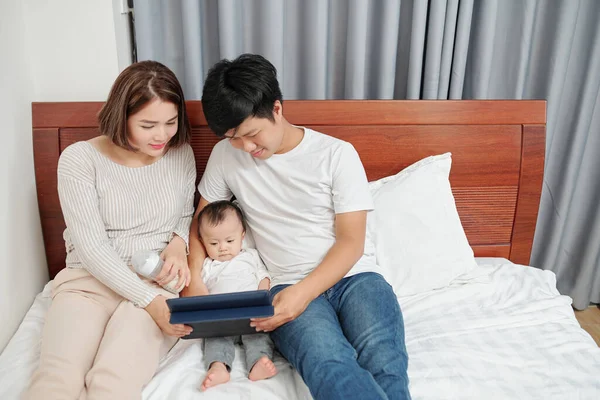 Jóvenes Padres Sonrientes Mostrando Dibujos Animados Video Educación Tableta Pequeño —  Fotos de Stock