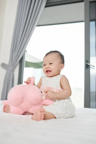 Riendo Feliz Niña Pequeña Sentada Cama Jugando Con Juguete —  Fotos de Stock