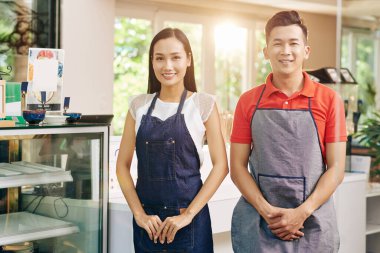 Önlüklü mutlu garsonların portresi karantinadan sonra kafeyi tekrar açtıktan sonra müşterilerle tanışmaya hazır.