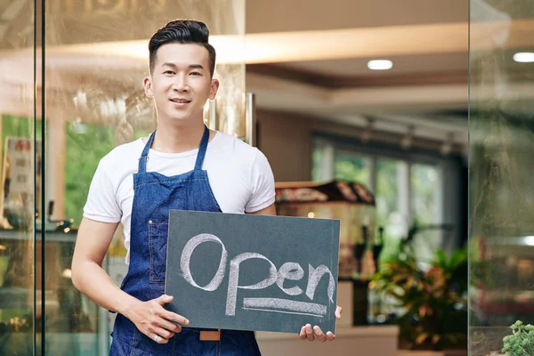 Позитивный Молодой Азиат Стоящий Входа Кафе Открытым Знаком — стоковое фото