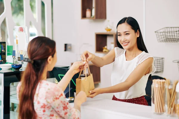 Genç Güzel Vietnamlı Bir Tezgahtar Bayan Müşteriye Kağıt Torba Veriyor — Stok fotoğraf