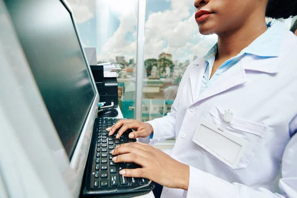 의사가 클리닉에서 컴퓨터를 사용하고 환자의 서류를 확인하는 모습이 — 스톡 사진