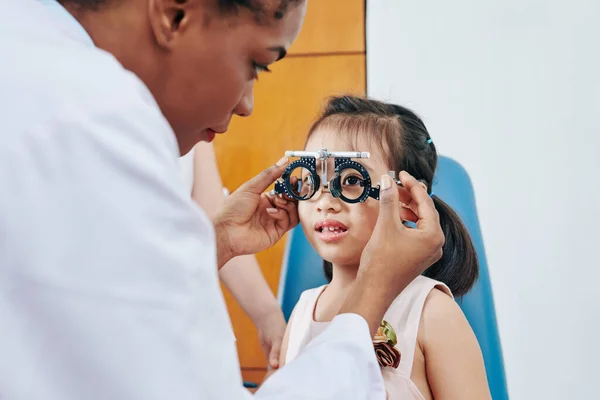 Детский Оптометрист Помогает Маленькой Девочке Надеть Тестовые Очки Проверке Зрения — стоковое фото