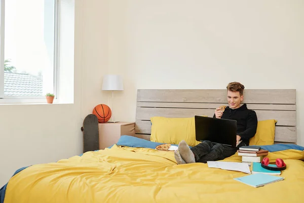 Estudante Ensino Médio Positivo Sentado Cama Comendo Pizza Assistindo Webinar — Fotografia de Stock