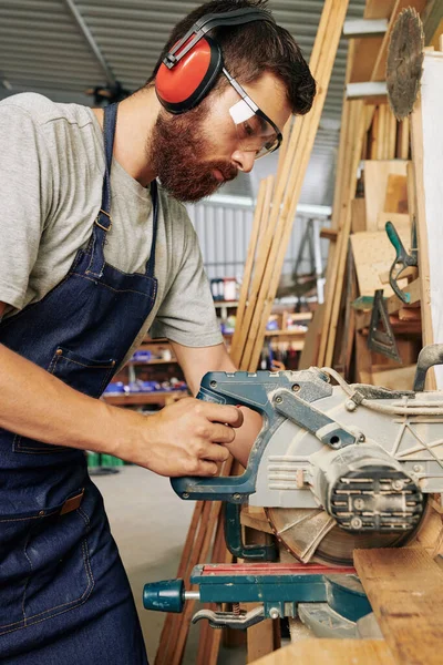 丸みを帯びた木の板を切断耳の真剣なプロの大工 — ストック写真