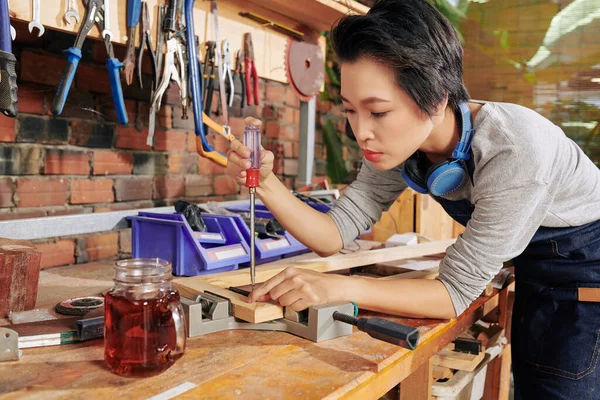 Skoncentrowany Wietnamski Stolarz Wykorzystujący Śrubokręt Imadło Łączenia Drewnianych Desek — Zdjęcie stockowe