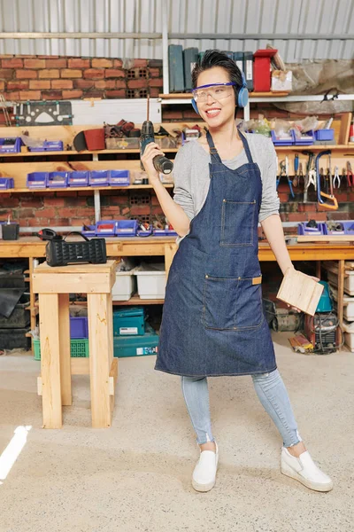 Carpinteiro Feminino Positivo Posando Sua Oficina Com Chave Fenda Tijolo — Fotografia de Stock