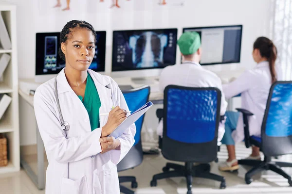 Serious Young Black Doctor Taking Notes Document Her Colleagues Working — Stock Photo, Image