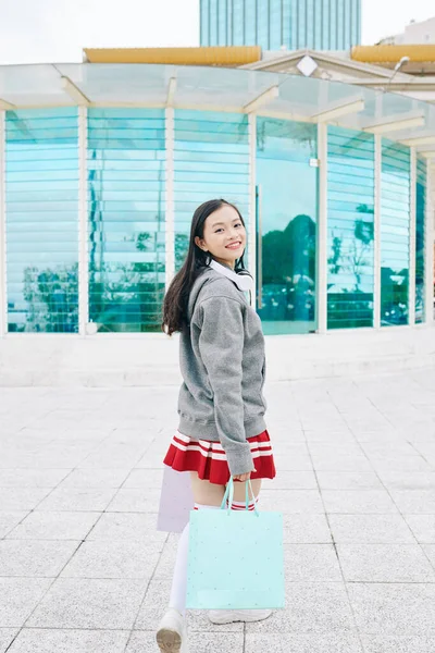 Teenagermädchen Mit Einkaufstüten Dreht Sich Und Lächelt Die Kamera — Stockfoto