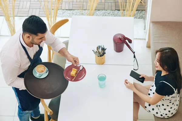 Garçom Trazendo Pedaço Bolo Delicioso Xícara Cappuccino Para Uma Jovem — Fotografia de Stock