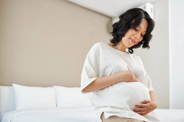 Feliz Embarazada Joven Asiática Sentada Cama Tocando Vientre — Foto de Stock