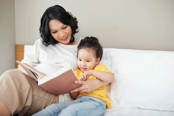 Fröhliche Mutter Und Ihre Kleine Tochter Lesen Gemeinsam Ein Buch — Stockfoto