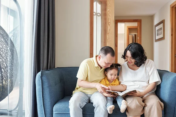 Feliz Padre Madre Vietnamitas Sentados Sofá Leyendo Interesante Libro Juntos — Foto de Stock