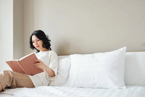 Mooie Aziatische Vrouw Zitten Bed Het Lezen Van Interessante Boek — Stockfoto