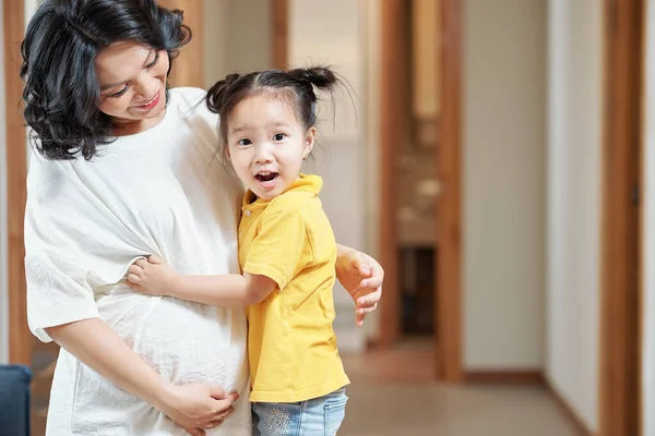 Happy Excited Little Girl Hugging Her Pregnant Mother Looking Camera — Stock Photo, Image