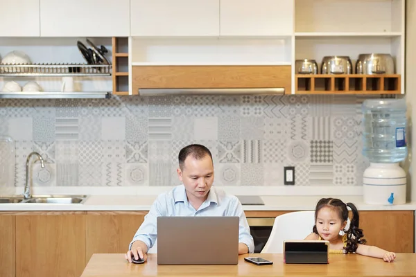 Serious Vietnamese Man Working Laptop Kitchen Table Little Daughter Watching — Stock Photo, Image