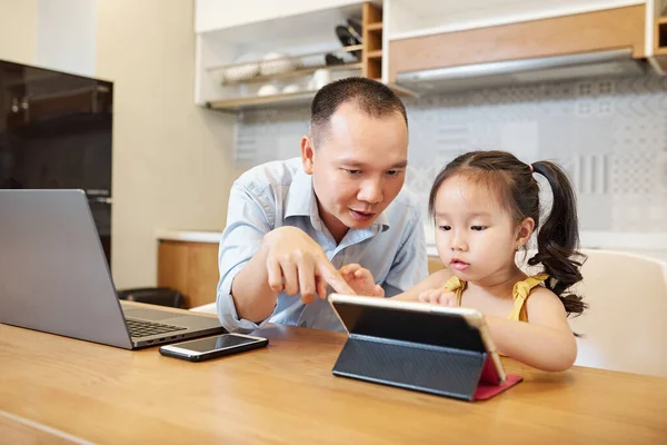 Padre Hija Pequeña Jugando Juntos Tableta Cuando Sienta Mesa Cocina — Foto de Stock