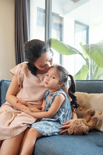 Mutter Sitzt Auf Sofa Und Küsst Ihre Traurige Kleine Tochter — Stockfoto