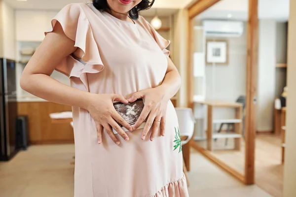 Обрезанное Изображение Улыбающейся Беременной Женщины Светло Розовом Платье Показывающее Ультразвуковое — стоковое фото