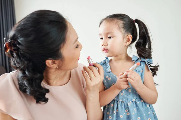 Curiosa Adorable Niña Vietnamita Mirando Madre Aplicando Lápiz Labial Rosa —  Fotos de Stock