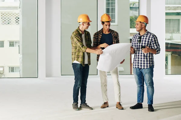 Grupo Jovens Empreiteiros Hardhats Discutindo Plano Construção Reunião Planejamento Trabalho — Fotografia de Stock