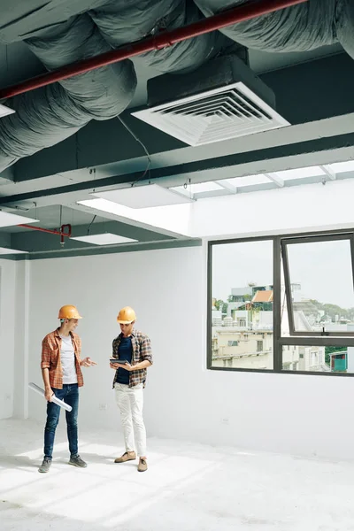 Positive Young Construction Engineers Standing Empty Room Checking Building Acceptance — Stock Photo, Image