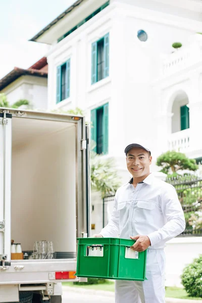 笑着送牛奶的越南人把牛奶箱放进货车行李箱 — 图库照片