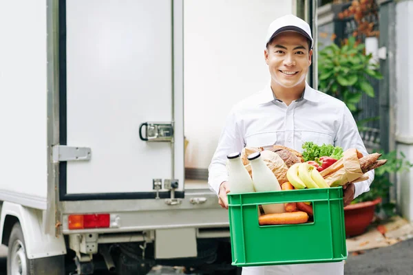 Retrato Correio Vietnamita Jovem Positivo Segurando Caixa Plástico Com Frutas — Fotografia de Stock