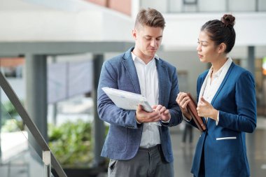Gururlu iş adamı, çalışmalarının sonuçlarını dışarıda beklerken meslektaşlarına gösteriyor.