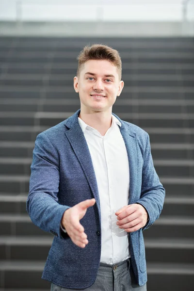 Portret Przystojnego Uśmiechniętego Młodego Przedsiębiorcy Wyciągającego Ramiona Uścisku Dłoni Patrzącego — Zdjęcie stockowe