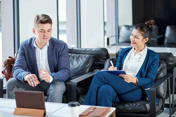 Sonriente Joven Empresaria Tomando Notas Planificador Cuando Habla Con Colega —  Fotos de Stock