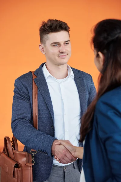 彼の新しい同僚の手を振る若いビジネスマンの笑顔 — ストック写真