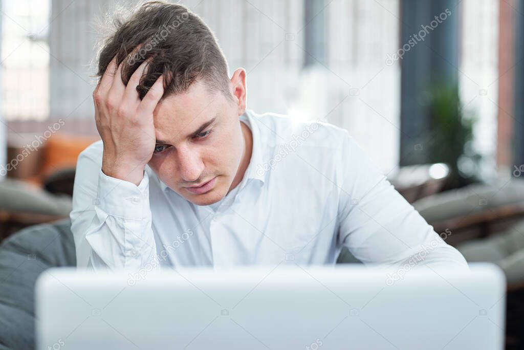Stressed and tired young businessman did not save the document he was working on all day long