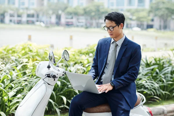 Fiatal Ázsiai Vállalkozó Robogón Dolgozik Laptop Válaszol Maileket Kollégák Ügyfelek — Stock Fotó