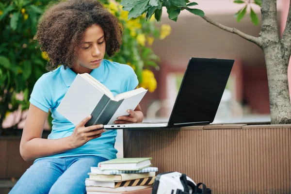 Colegiala Raza Mixta Rizada Concentrada Leyendo Libro Interesante Campus —  Fotos de Stock